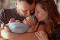 Mãe e pai com o bebé ao colo durante o período de subsídio de parentalidade