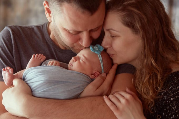 Mãe e pai com o bebé ao colo durante o período de subsídio de parentalidade
