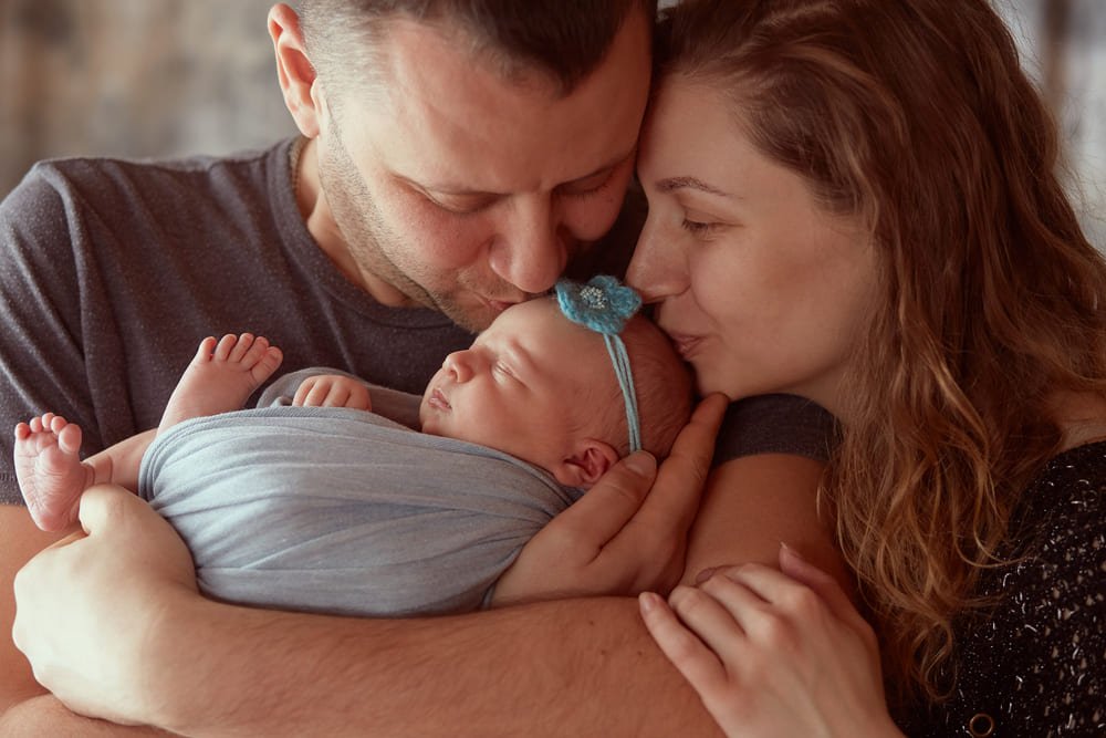 Mãe e pai com o bebé ao colo durante o período de subsídio de parentalidade